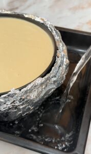 pour hot water in a bigger pan and place the cheesecake pan on top