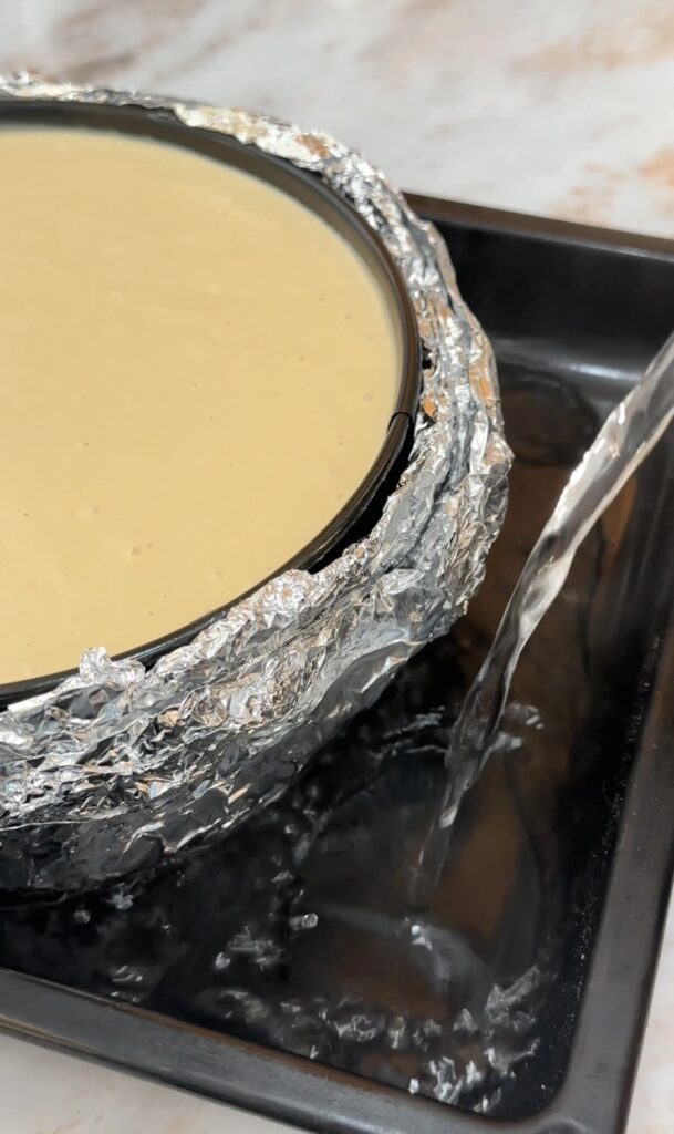 pour hot water in a bigger pan and place the cheesecake pan on top