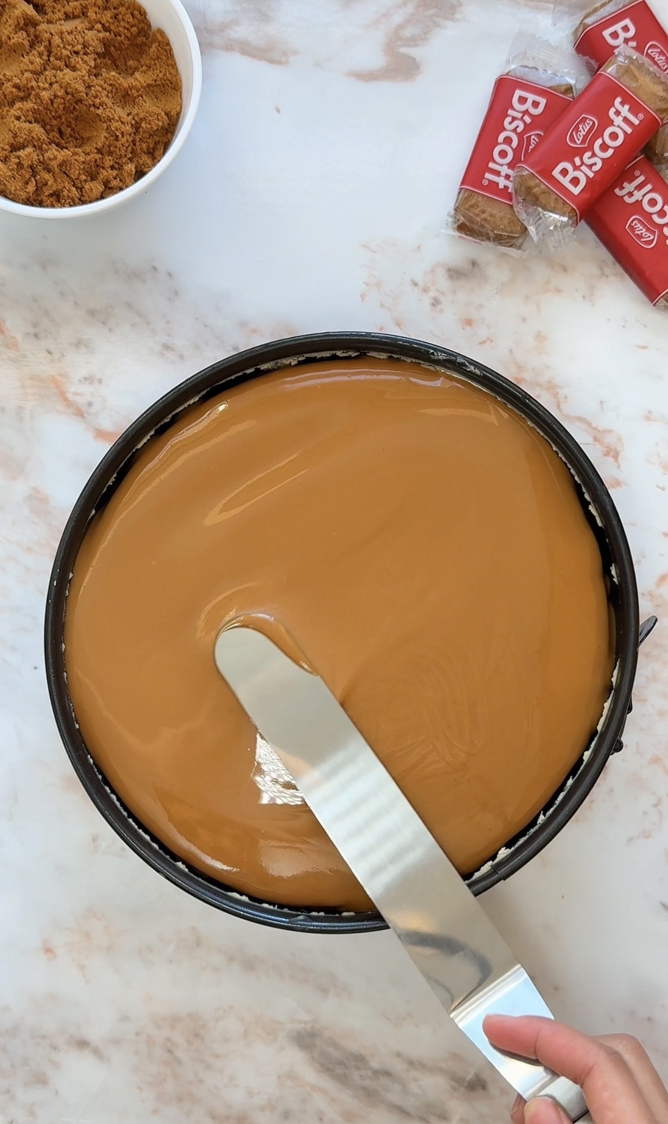 pour the melted biscoff on top of the cheesecake