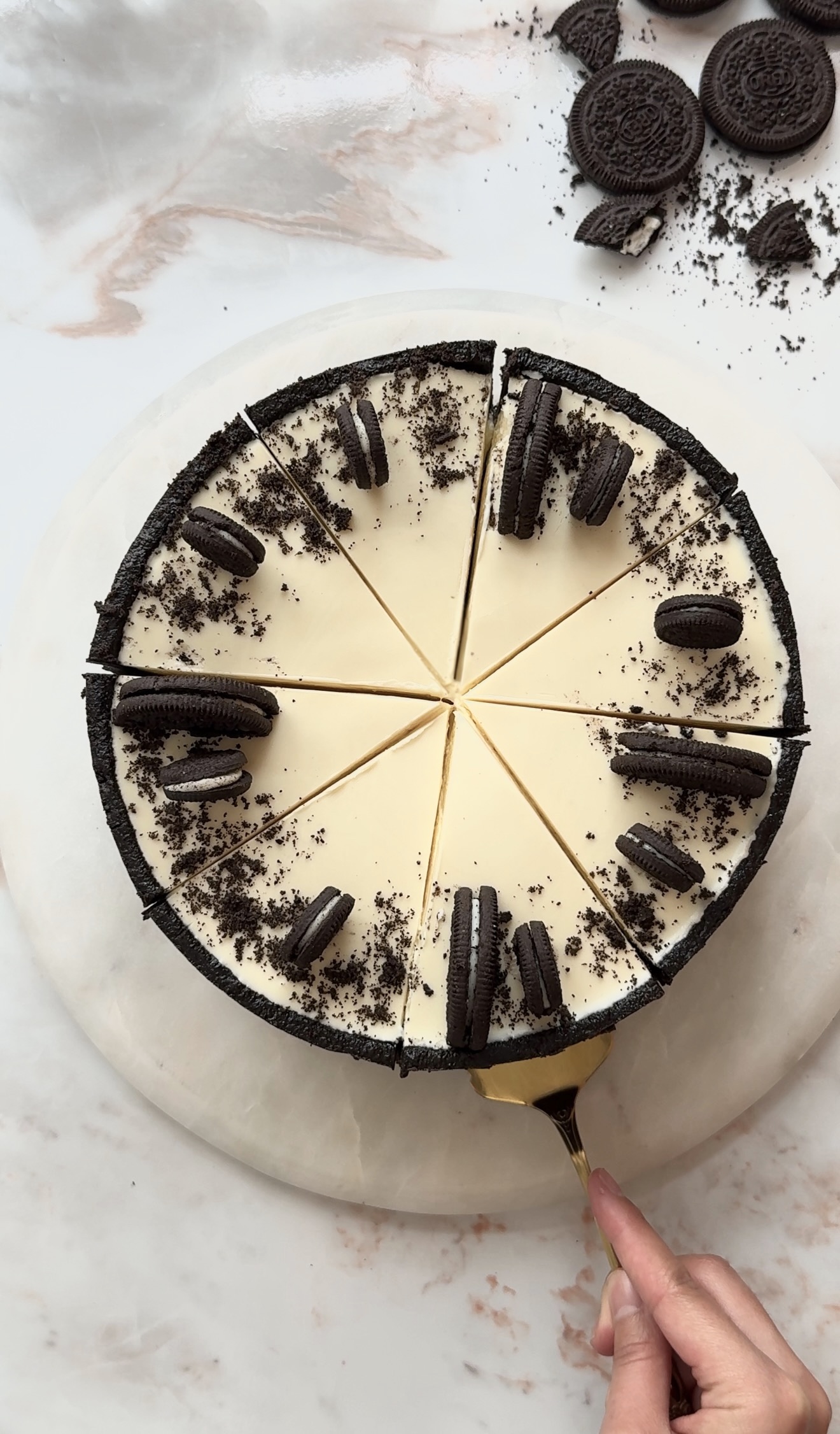 Creamy no bake Oreo cheesecake topped with melted white chocolate and crushed Oreo cookies