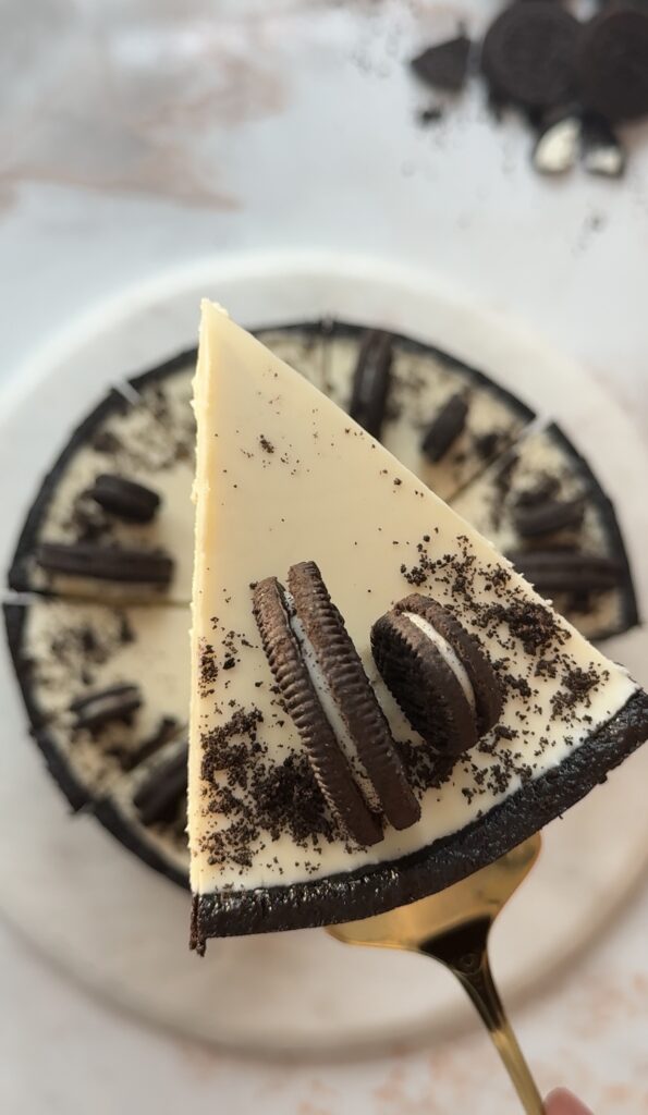 Creamy no bake Oreo cheesecake topped with melted white chocolate and crushed Oreo cookies